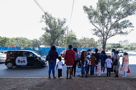 Families wait to cross the road along Uhuru highway as they walk to Uhuru Park to celebrate and have fun on Christmas day. Kenyans in Nairobi celebrate Christmas day by visiting Uhuru park and traveling up country to visit with their families.