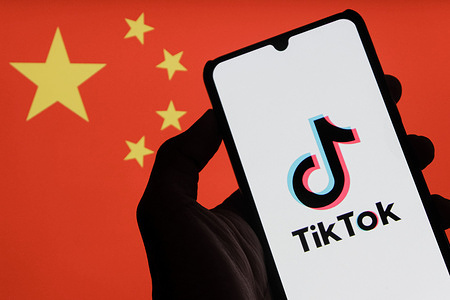 In this photo illustration, a TikTok logo is seen displayed on a smartphone with the Chinese flag in the background.