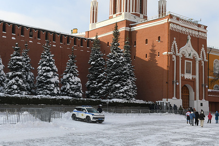 A police car near the walls of the Moscow Kremlin and the Nikolskaya Tower.