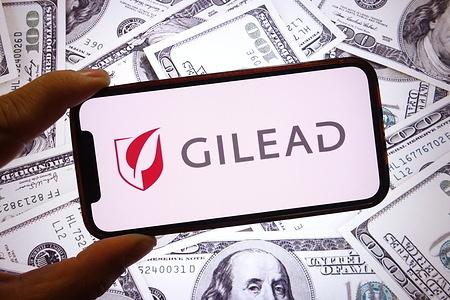 In this photo illustration, the Gilead Sciences company logo is seen displayed on a smartphone screen.