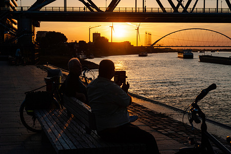 A man is seen taking a photo of the beautiful sunset at the Waal river. Due to the ongoing drought, the Netherlands officially has a water shortage, the government announced. The scarce water will be distributed according to the legal agreements so that dikes, peatlands, and very vulnerable nature areas are supplied with water for as long as possible. More measures may follow in the coming weeks. With two-thirds of the Dutch population living below sea level, droughts can quickly become an acute problem in the Netherlands, leading to rivers silting up and hampering water traffic. Due to the increasing drought, houseboats are lying on the muddy bottom, at the Ooijpolder area near Nijmegen.