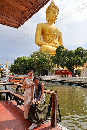 Tourists pose for a photo in front of the Big Buddha statue at Wat Paknam in Bangkok.