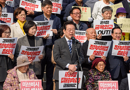 South Korea's main opposition Democratic Party leader Lee Jae-myung (C) speaks as labour victims Yang Geum-deok (R bottom) and Kim Sung-ju (L bottom) listen during a rally against the South Korean government's announcement of a plan over the issue of compensation for forced labors at the National Assembly in Seoul. A group of civic groups on March 7 condemned the government's plan to compensate victims of Japan's wartime forced labor on its own, saying the decision amounts to national humiliation similar to Korea's 1910 forced annexation by Japan. The government of President Yoon Suk Yeol announced the plan March 6 in an effort to restore strained relations with Tokyo. It calls for establishing a foundation charged with collecting public donations and compensating more than a dozen victims. Critics, including some victims, civic groups and the main opposition Democratic Party, bristled strongly at the decision, arguing that it makes no sense to compensate victims with public donations, rather than money from Japanese companies that exploited them for hard labor.