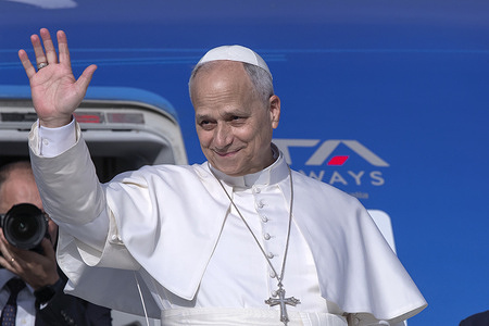 Pope Leo XIV waves as he boards his plane to Madrid to begin his six-day apostolic journey to Spain at Fiumicino International Airport.