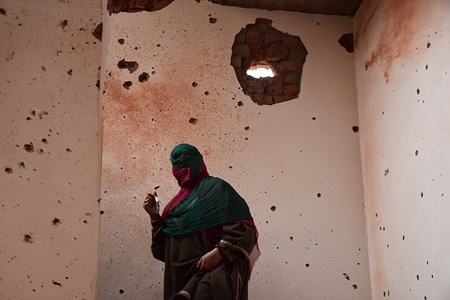 Women walks inside the partly damaged building in an encounter in Srinagar.
4 Killed and several injured in an encounter between Indian forces and militants at chatabal area of Srinagar summer capital of Indian Kashmir on Saturday. Three militants were killed during a brief shootout after government forces laid seige around densely populated chatabal area of Srinagar. A young man also died after he was hit by the armoured vehicle during the clashes between the residents and police force as residents tried to help the Militants in escape.