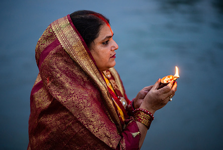 A devotee offering oil lamp and prayers as part of rituals during the celebration at the Bagmati River. The Chhath festival is celebrated to worship Sun God where devotees pay homage to the sun and his sister 'Chhathi Maiya'. The Chhath Puja is performed in order to thank Sun god for sustaining life on earth and to request the granting of certain wishes.