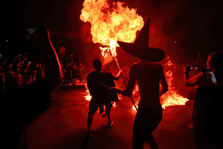 A reveller performs with fire, during the parade.
Salvadorans celebrated traditional "La Calabiuza" (day of the dead) where revelers dress up as characters from local folklore on the eve of "DÌa de los Muertos" or "Day of the dead".