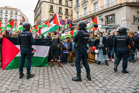 Police officers control demonstrators with flags of Western Sahara during a protest. Citizens held a protest against the Spanish government's support for Morocco's autonomy plan for Western Sahara, in the provinces square in Madrid, Western Sahara is designated by the UN as a "non-self-governing territory" whose people "have not yet achieved a full measure of self-government". Morocco controls 80 percent of the territory, while the rest, is almost a landlocked border area with Mauritania, is run by the Polisario Front.