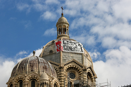 A banner calling for a general strike hangs on the cathedral of Marseille on the sidelines of the demonstration against the pension reform. French unions have called for a 9th day of action against the French government's pension reform which would raise the retirement age from 62 to 64. French President Emmanuel Macron says he will force through the pension reform using Article 49.3 of the French Constitution. Article 49.3 allows the government to force the passage of a bill without a vote of parliament
