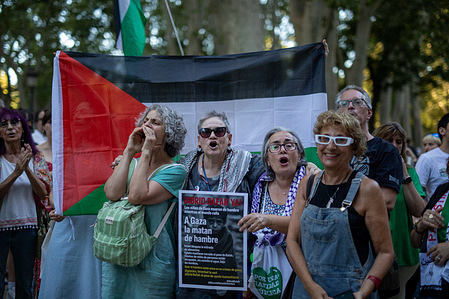 A group of protesters carries signs and Palestinian flags during a demonstration against the genocide in Gaza in front of the Ministry of Health.