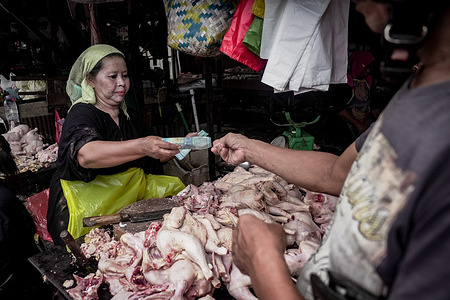 A chicken seller takes payment from a customer at Pasar Lama, a traditional market. According to the Indonesian Central Statistics Agency, Indonesia’s economy expanded 5.12% year-on-year in Q2 2025, but with food inflation at 3.99%, average monthly wages stuck at Rp 3.09 million, and unemployment at 4.76%, many low-income families still struggle even as the national poverty rate fell to 8.47%, the lowest in two decades.