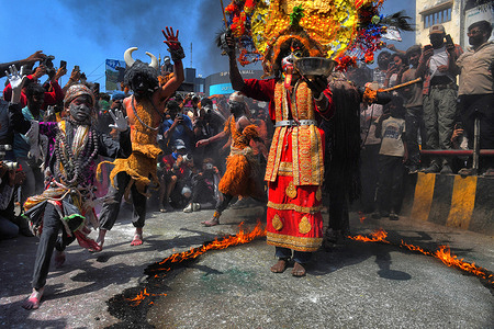 Devotees perform a fire-breathing act during a religious procession, 'Masaan' or 'Bhasma' Holi, celebrated with ashes of the pyre, in Varanasi.