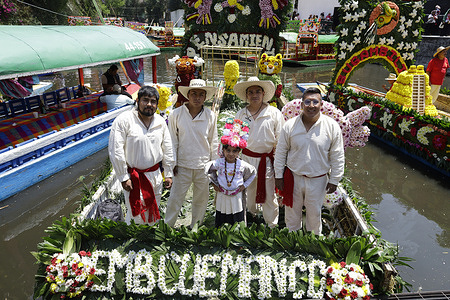 A young girl and other young people aboard a trajinera (a traditional boat) at the Xochimilco pier in Mexico City wear traditional clothing during the Festival. The event, held aboard Trajineras decorated with a multitude of Xochimilco flowers, brought together local residents, visitors, and authorities to demand an end to the blockade against Cuba, part of U.S. President Donald Trump's actions against the island to prevent the Caribbean nation from accessing oil and other fuels.