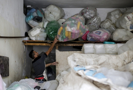 Palestinian youth pulls out bags of plastics at a collection point.
Palestinian youths spend 15 hours a day roaming the streets looking for minerals and plastics from the garbage piles in Jabalia camp which they sale to traders for a pay of about US $ 2.5 per day.