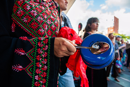 A Palestinian woman seen making noises with a pot during the rally. Outside the train station, people gathered and made loud noises with pots and instruments to call for an end to the famine in Gaza. 
For months, Israel stopped food shipments to Gaza far below starvation rations. Now the death toll is rising rapidly. These protests are occurring simultaneously at several train stations nationwide.