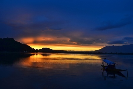 A boatman seen rowing his boat during a stormy sunset at Dal Lake in Srinagar, Indian administered Kashmir.