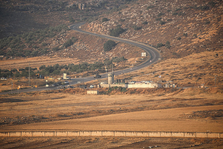 An Israeli military checkpoint is closed in the West Bank city of Nablus as Iranian missiles are launched toward targets in Israel. Meanwhile, Israeli air defense systems attempt to intercept the incoming missiles.