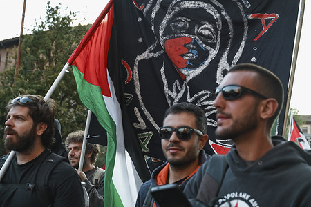 A protester holds a flag with a women’s face and Palestinian colors during the demonstration. The Pro-Palestine demonstration in Rome organized by the movement Giovani Palestinesi Italiani (Young Italian Palestinians) was attended by thousands of people, including students, families and trade unions, who asked for ceasefire in Gaza and Palestine and the immediate release of Global Sumud Flotilla members, detained in Israel.