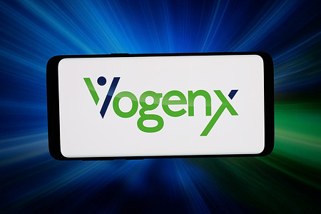 In this photo illustration, the US biotechnology company Vogenx Inc. logo is seen displayed on a smartphone in front of abstract background on computer screen.