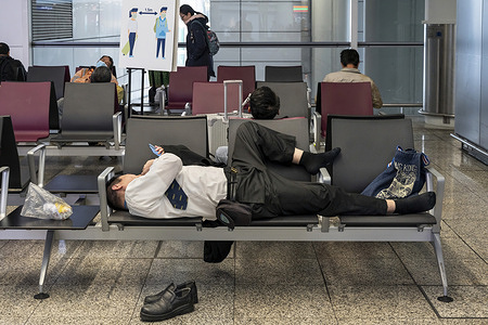 A passenger rests on a bench at the arrival hall in Hong Kong's Chek Lap Kok International Airport. Visitors to Hong Kong would no longer require to undergo the "0+3" covid (Covid-19) medical surveillance period after the government ended travel restrictions.