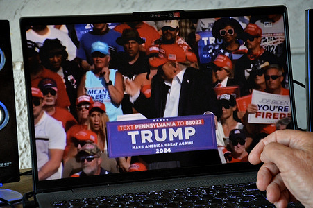 In this photo illustration, a man watches a video of Trump's attack on his computer. Former US President Donald Trump was attacked and shot in the right ear while holding a rally in Butler, Pennsylvania, as part of his campaign for the US presidential election in 2024.