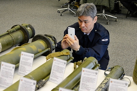 A representative of the Japanese diplomatic service takes a photo on his phone of samples of destroyed Russian military ammunition, electronic and food supplies, which were collected during military operations and presented at a briefing of representatives of the Security and Defense Forces of Ukraine on operational information on the front of the Russian-Ukrainian war. Deputy Minister of Defense of Ukraine Hanna Malyar made a briefing to the representatives of the Security and Defense Forces of Ukraine at the Military Media Center about the increase in the deployment of Russian troops in Ukrainian territory. They have mobilized the troops from the training grounds of Belarus and Russia to the area of hostilities and border areas.