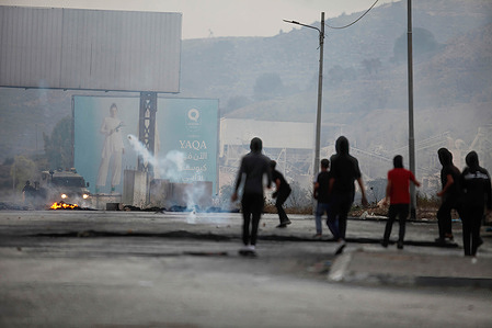 Israeli army forces fire tear gas canisters at the Palestinian youths in front of the Hawara military checkpoint, which is under Israeli control, during a protest against the closure of all entrances and exits to the city of Nablus in the occupied West Bank.