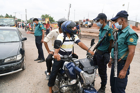 Police officers stop a motorcyclist at a checkpoint at the Gabtoli area during the covid-19 lockdown. Vehicle owners need to provide valid information to police officers that their movement across the city are necessary in order to curb the spread of the virus.