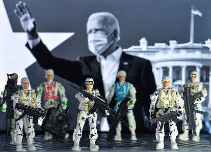In this photo illustration toy soldiers seen in front of the presidential inauguration advertisement with the image of the US President-Elect, Joe Biden, displayed on a screen in the background.