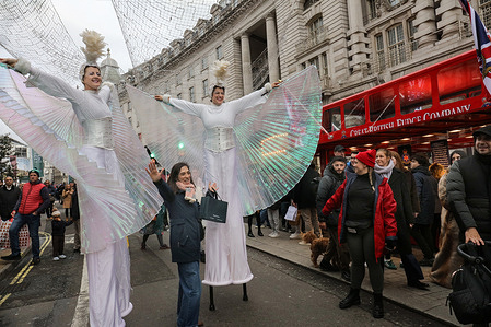 Elegant stilt-walkers bring the feeling of festival to shoppers as they walk along a traffic-free Regent Street. Regent Street was closed to traffic for the first time since 2020 to free the road for Christmas shoppers and festive celebrations. The road was shut between Oxford Circus and Piccadilly Circus to transform it into a festive mile of shopping, entertainment, and refreshments organised by the Crown Estate.