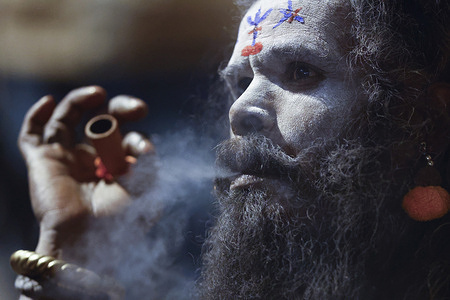 A Sadhu smokes a chillum filled with marijuana inside the premises of the Pashupatinath Temple on the eve of the Maha Shivaratri festival dedicated to Lord Shiva.