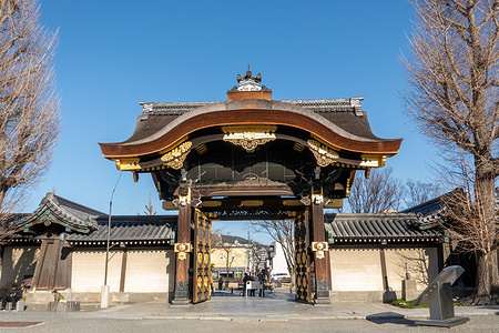 The ornate wooden entrance gate of Nishi Hongan-ji Temple is seen in Kyoto, featuring traditional Japanese architecture and detailed gold accents. Nishi Hongan-ji is a historic Buddhist temple in Kyoto and a UNESCO World Heritage Site known for its grand wooden architecture and richly decorated interiors. As the head temple of the Jodo Shinshu sect, it remains an active place of worship as well as a major cultural landmark.