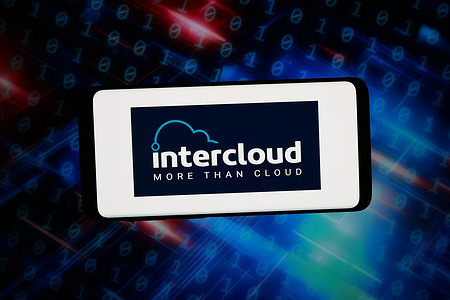 In this photo illustration, the network connectivity company Intercloud logo is seen displayed on a smartphone in front of abstract background on computer screen.