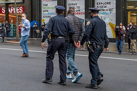 New York Police Department (NYPD) Officers arrest an activist during a protest.
New York Police Department (NYPD) Officers arrested two activists after they refused to clear the road during a protest outside the Netherland consulate in Manhattan blocking traffic and calling for reparations for Blacks in New York.