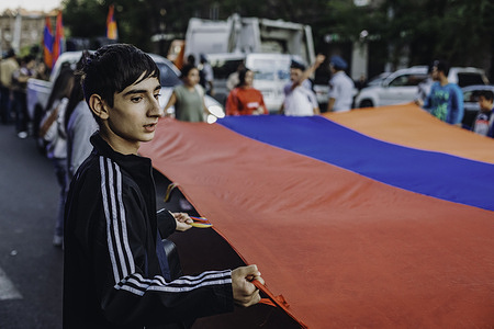A young man carries an Armenian flag during a candlelight march to the cemetery in Yerablur to honour the Armenians fallen soldiers of the last Nagorno-Karabakh war, which ended with the defeat of Armenia against Azerbaijan.Armenians march with candles to the cemetery of Yerablur in Yerevan to honour the fallen soldiers in the war of Nagorno-Karabakh against Azerbaijan.