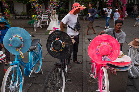 Bicycle lessors at Taman Fatahillah stand next to their colorful bikes at Taman Fatahillah.