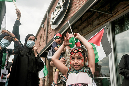 A young girl waves a Palestinian flag, during a large free Palestine rally at the Arab American Museum.
Hundreds of residents of Detroit and Dearborn Michigan took to the streets to march and protest the forced expulsion of Palestinians from Sheikh Jarrah in East Jerusalem and the ongoing air strikes on Gaza by Israel that have killed 145 Palestinians including 41 children. The protesters marched through Dearborn from the Arab American Museum and held Palestinian flags and wore traditional Kafias.