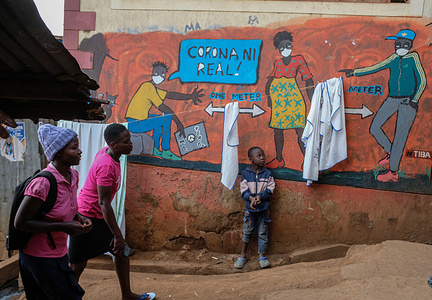 A boy poses by a mural promoting awareness of the coronavirus disease (COVID-19) in Kibera.