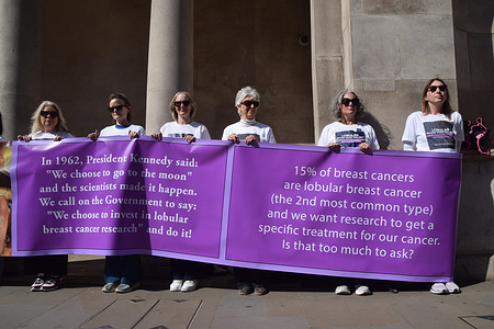 Women holding banners stage a vigil in Whitehall raising awareness of lobular breast cancer and calling on the government to fund research on this form of cancer.