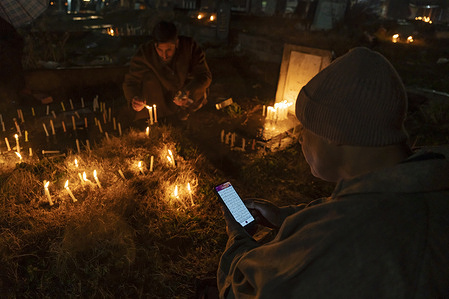 A Kashmiri Muslim man uses his phone to recite verses from the holy Qur’an near the graves of his relatives during the Shab-e-Barat observance. Shab-e-Barat is observed by Muslims on the 14th–15th night of Sha‘ban, the eighth month of the Islamic calendar. The night is marked by prayers and supplications, as believers seek forgiveness and hold the belief that God determines human destinies for the coming year. For Twelver Shia Muslims, the occasion carries added significance as it coincides with the birth anniversary of the 12th Imam, Muhammad al-Mahdi. Shia Muslims commemorate the night by lighting candles at the graves of relatives, illuminating homes and graveyards with lamps, offering prayers at burial sites, and observing nightlong prayers as expressions of devotion and remembrance of their Imam.