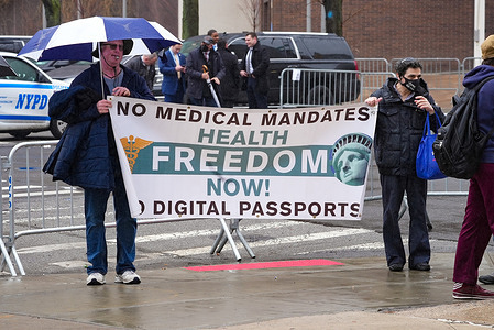 Anti-medical mandates protestors seen with a banner at NYPD Police Headquarters at One Police Plaza before the arrival of US President Biden in the wake of police killings.