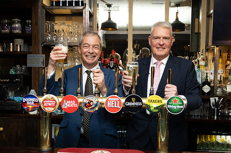 Nigel Farage, Leader of Reform UK and Lee Anderson, MP pull pints during a Reform UK press conference on their plan to cut taxes to save pubs and high streets at The Loose Box Pub in London.