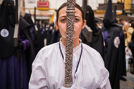 A Christian girl is carrying a silver cross through the streets of Seville as she takes part in a procession during the Holy Wednesday to mark the Holy Week celebrations. The Brotherhood of San Bernardo takes the procession of el Cristo de la Salud and la Virgen del Refugio to the streets after two years without celebrating Holy Week due to the restrictions of the Covid-19 pandemic.
