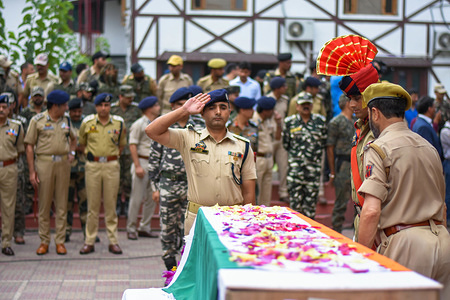 A Senior Indian police officer salutes the coffin containing the body of Parvaiz Ahmad during a wreath-laying ceremony in Srinagar, Indian administered Kashmir. A policeman of the special operations group (SOG) was killed and four, including a policeman and three CRPF personnel, were injured in an encounter which broke out in wee hours of Sunday in Batamaloo area of Srinagar. The militants however managed to escape while two of their accomplices were detained, police said.