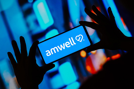 In this photo illustration, the Amwell logo seen displayed on a smartphone.