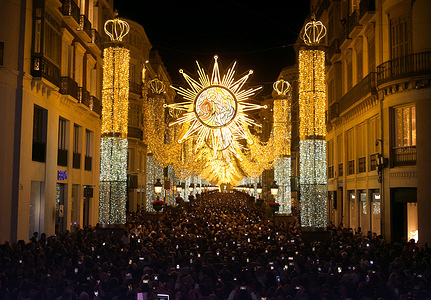People are seen using their mobile phones as they watch the switching on of the new Christmas lighting on Marques de Larios street. Every year, Malaga city turns on its Christmas lights to mark the start of Christmas season, where thousands of people gather in downtown city to see a new Christmas decoration and light shows