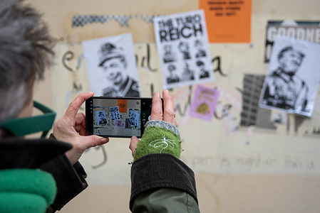 A member of public takes photos of posters at the Old Town in Margate. Satirical, political poster series called "The Turd Reich" appeared on the wall at the Old Town in Margate.