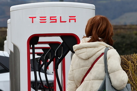 A woman seen at a Tesla electric car charging station.