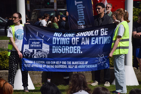 Protesters hold a 'No one should be dying of an eating disorder' banner in Parliament Square during the annual 'Dump The Scales' demonstration, calling on the government to take action and implement a national eating disorder strategy.
