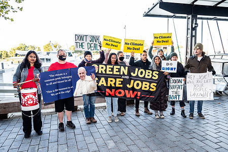 Protesters hold banners and placards expressing their opinion during the protest.
 A protest against the legislative positions that U.S. Senator Joe Manchin (D-WV) has taken regarding the budget reconciliation package. The protest took place near the dock where the Senator's boat is docked in Washington, D.C.
